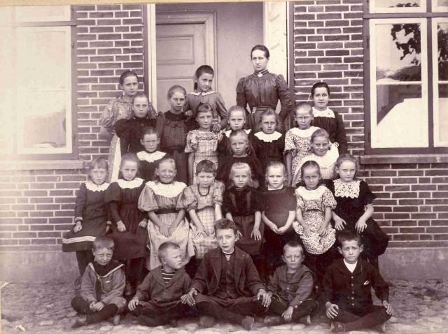 Lærerinde Frk. Markussen med elever foran friskolen Frederikkes-Minde i Riis, Fårevejle Sogn. (B905)