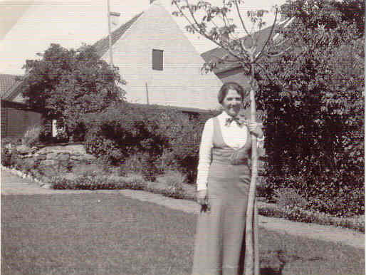 Margrethe Helms ved sit valnøddetræ. Den hvide gavl er Traktørsted Vilhelm Nielsen - 1907 (B90304)